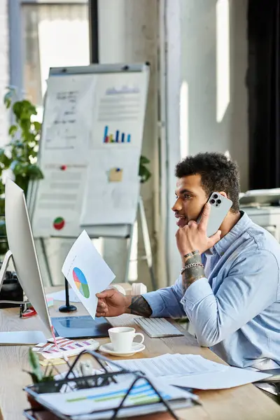 Focused individual on a phone call while analyzing data in an inviting workspace setting — Stock Photo