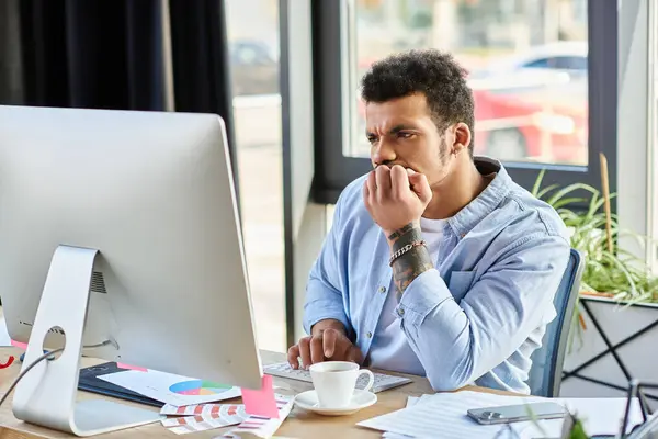 Man appears deep in thought while typing on computer at a contemporary workspace — Stock Photo