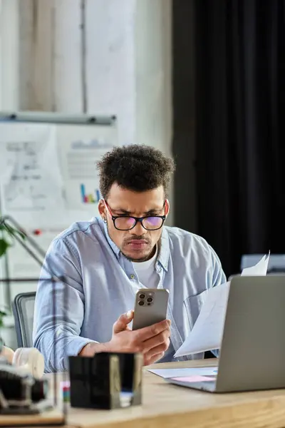 Handsome man intensely examines paperwork and checks his smartphone in a stylish office. — Stock Photo