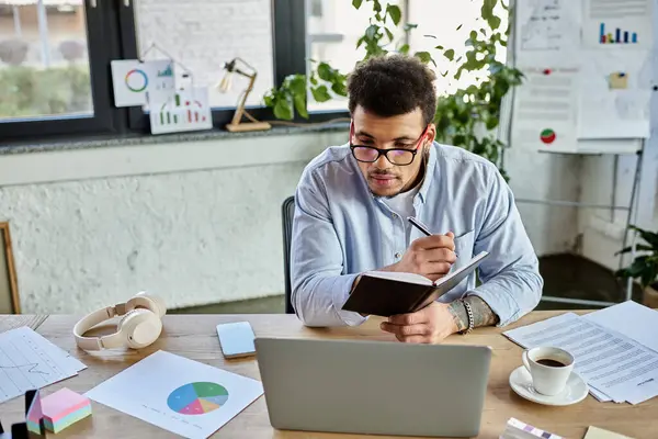 A handsome man writes notes while analyzing data in a modern office filled with greenery — Stock Photo