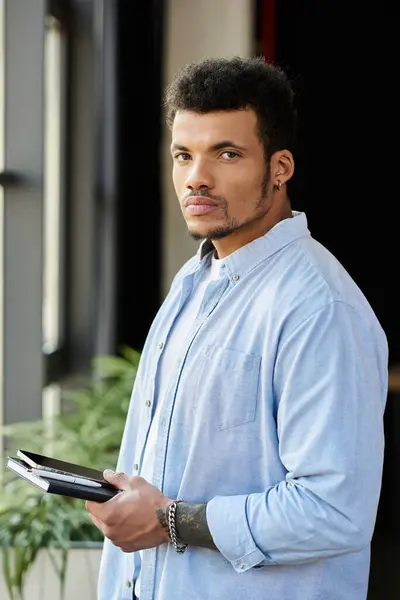 Confident individual with a charming look engages with his notebook while surrounded by greenery. — Stock Photo