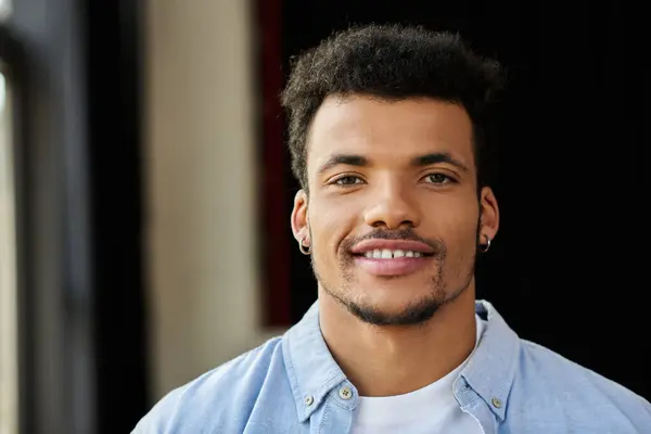 A charismatic man with a confident smile stands against a softly lit background, exuding charm. — Stock Photo