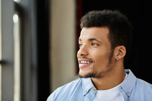 A confident young man with curly hair enjoys the view outside while smiling. — Stock Photo
