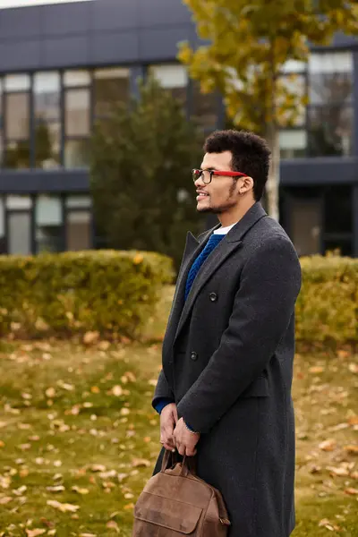 A charming man stands quietly in a park, embracing the beauty of the fall season. — Stock Photo