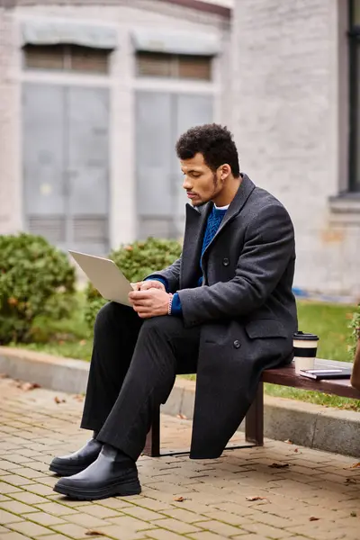 Concentrated individual using a laptop outdoors, embracing the serenity of nature in autumn. — Stock Photo