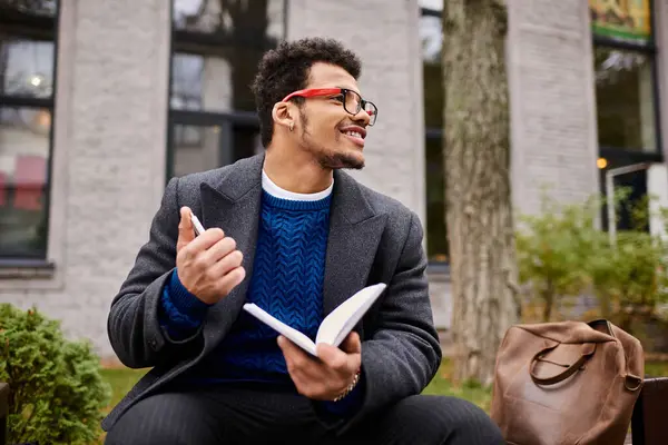 Man reads a book with enthusiasm while relaxing at a charming urban park setting. — Stock Photo