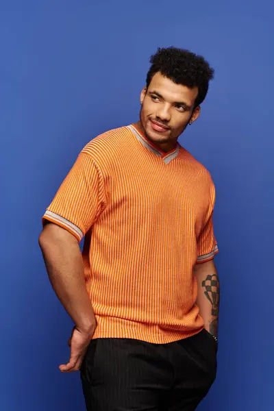 Vestido de laranja elegante, um homem bonito está confiante, exalando charme e carisma. — Fotografia de Stock