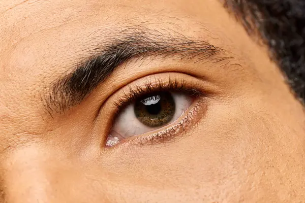 Handsome man captures attention with his mesmerizing gaze and attractive features in soft light. — Stock Photo