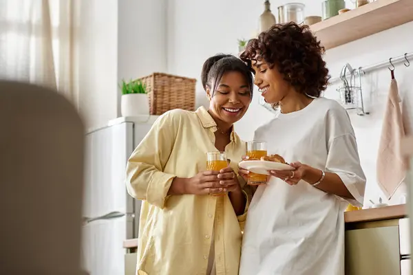 A young Black couple shares smiles and drinks over breakfast in the morning light. — Stock Photo