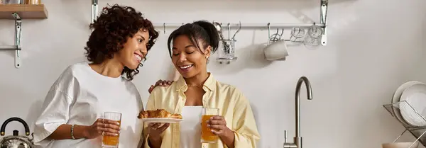 Morning light fills the kitchen as a loving couple shares a joyful breakfast moment, banner — Stock Photo