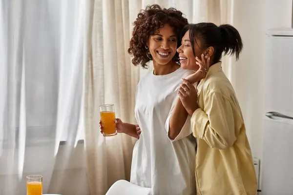 Jeune couple afro-américain dégustant un verre petit déjeuner avec des sourires dans un cadre élégant le matin. — Photo de stock