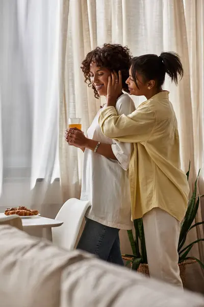 A joyful lesbian couple enjoys a cozy breakfast together in their stylish apartment. — Stock Photo