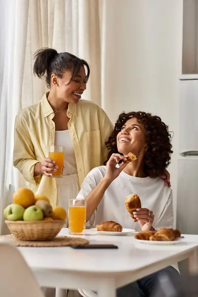 Due giovani donne condividono un delizioso momento di colazione, godendosi reciprocamente la compagnia. — Foto stock