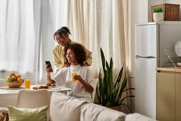 Un jeune couple afro-américain prend son petit déjeuner ensemble, partageant rires et amour. — Photo de stock