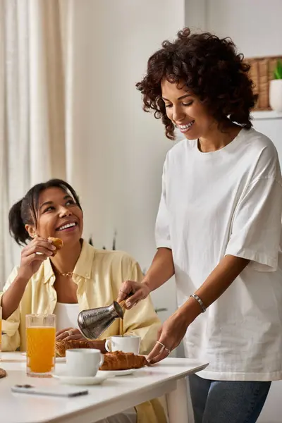 Two young women share a delightful breakfast together, enjoying each others company and laughter. — Stock Photo