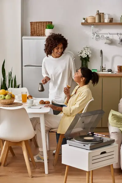 Two young women embrace love and connection during a cozy breakfast in their stylish home. — Stock Photo