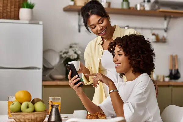 Two women share laughter and love over breakfast in their stylish morning space. — Stock Photo