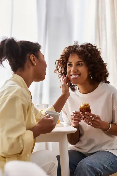 Two young women share a joyful breakfast moment in their stylish apartment. — Stock Photo