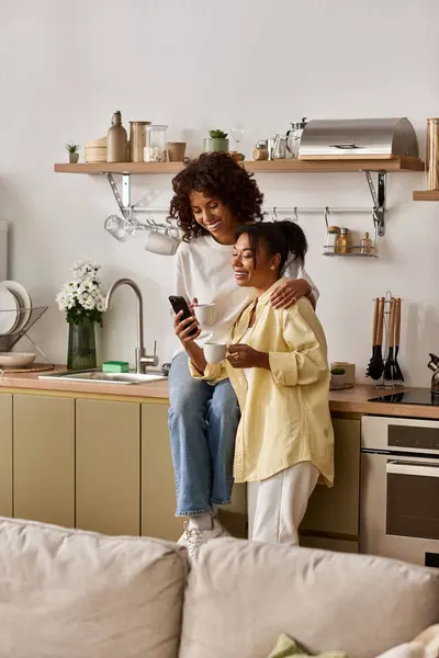 A young African American couple shares laughter and love in their sleek modern kitchen. — Stock Photo