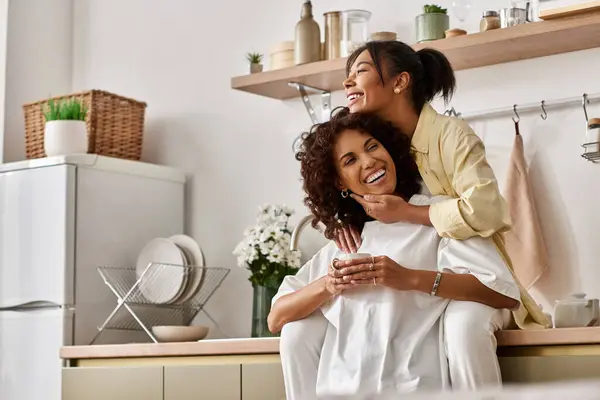 A young lesbian couple shares laughter and love in their stylish home together. — Stock Photo