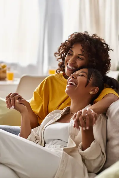 Two young women laugh together in their modern apartment, enjoying each other's company. — Stock Photo