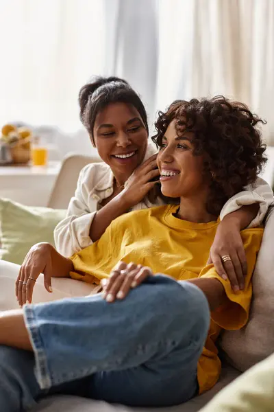 A young lesbian couple enjoys a cozy afternoon, sharing laughter and warmth in their stylish home. — Stock Photo