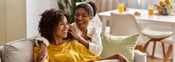 Two young women enjoy a joyful moment together in their stylish living space, sharing warmth, banner — Stock Photo