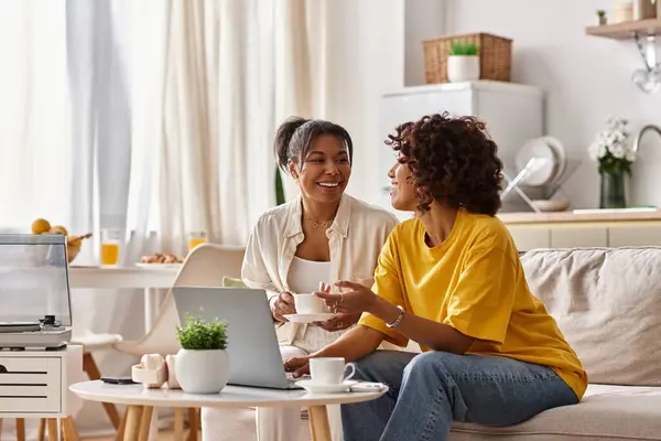 A young African American couple shares smiles and work moments in their cozy apartment setting. — Stock Photo
