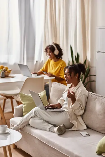 Ein lebhaftes afroamerikanisches Paar teilt seinen häuslichen Arbeitsbereich und engagiert sich gemeinsam während der Arbeit. — Stockfoto