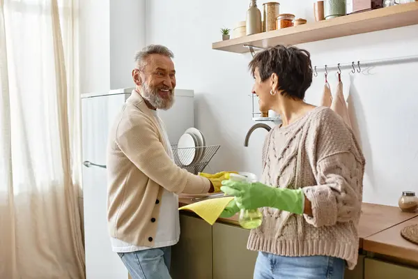 A couple enjoys quality time as they clean their bright and inviting kitchen space. — Stock Photo