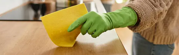 Зрелая женщина убирает на кухне, ее муж на заднем плане, разделяя моменты в повседневной рутине. — стоковое фото