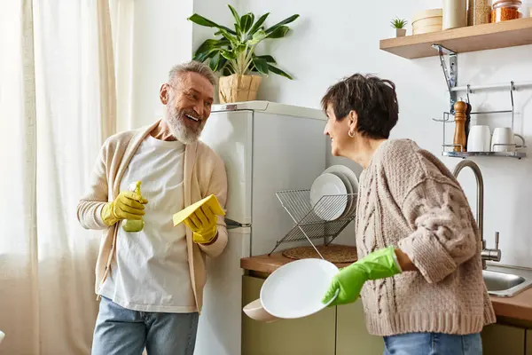 Glückliches Paar teilt Lachen und Wärme beim Aufräumen in der einladenden Küche. — Stockfoto