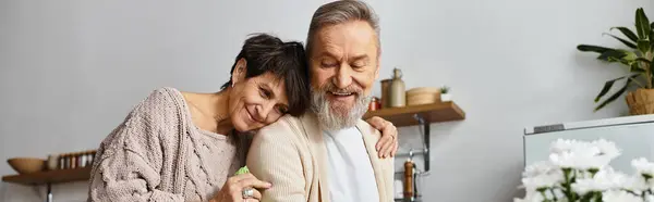 Mature couple enjoys each others company while preparing a meal in their inviting kitchen space. — Stock Photo
