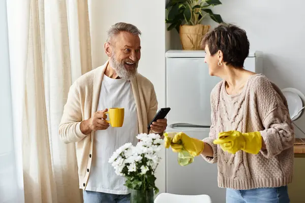 A cheerful couple shares smiles while tidying up their bright kitchen space. — Stock Photo