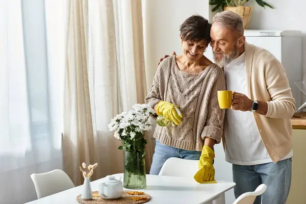 A happy couple shares joyful moments as they clean their kitchen with love and care. — Stock Photo