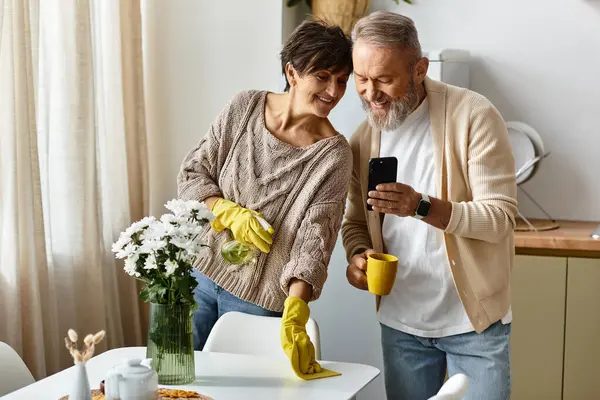 Um casal maduro compartilha um momento leve, sorrindo enquanto limpam e desfrutam uns dos outros da companhia. — Fotografia de Stock