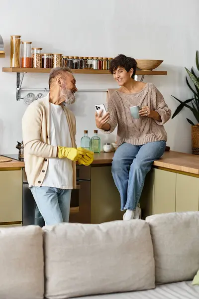 A happy couple engages in a lighthearted conversation while preparing drinks together. — Stock Photo