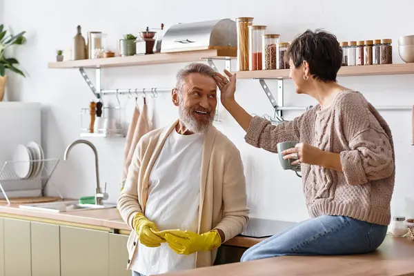 A joyful couple shares a light hearted moment while preparing food in their stylish kitchen. — Stock Photo