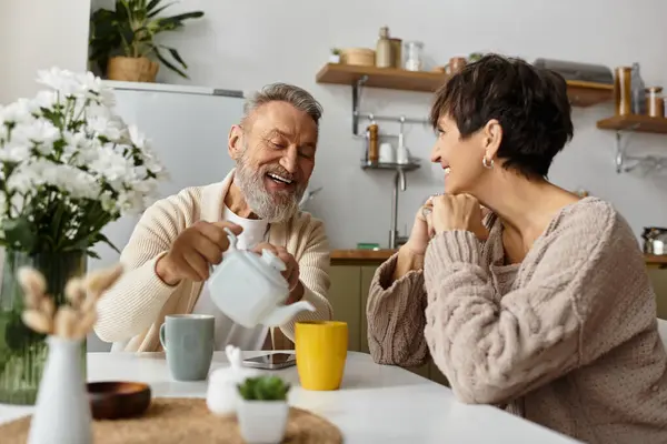 A couple engages in a delightful conversation over tea, radiating warmth and happiness. — Stock Photo