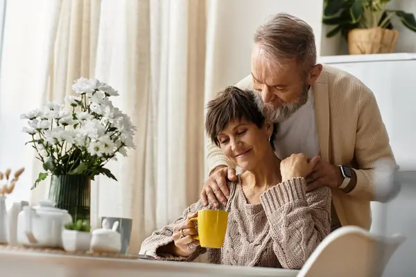 A loving couple shares a tender moment over coffee, surrounded by warmth and flowers. — Stock Photo