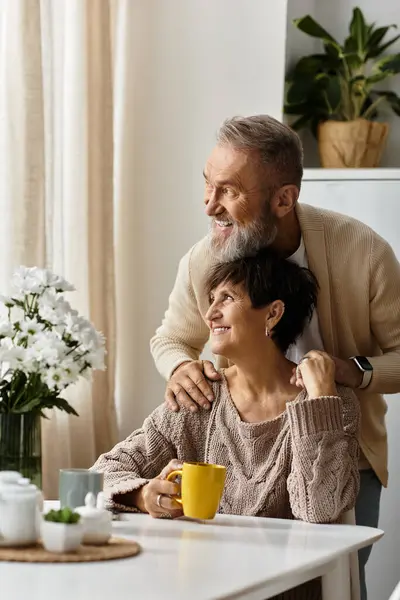 A cheerful couple relaxes at home, sharing smiles and warmth over coffee in a cozy setting. — Stock Photo