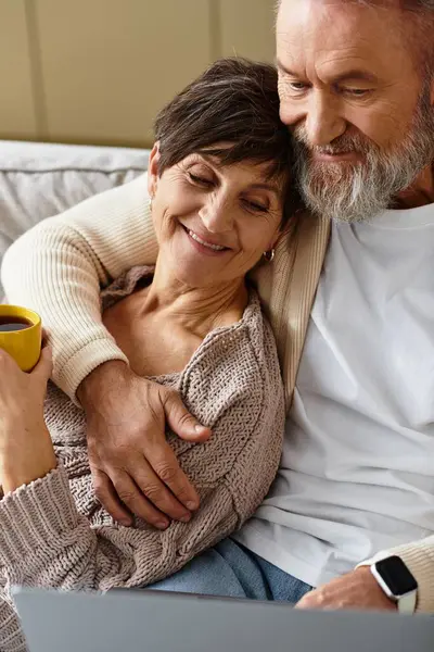 Warm embraces and shared smiles fill the air as the couple relaxes at home with a cup of tea. — Stock Photo
