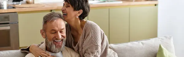 A woman lovingly embraces her smiling partner as they share laughter in their warm home. — Stock Photo