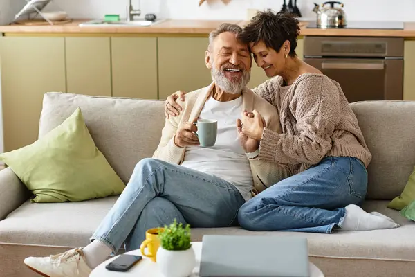Couple enjoys a joyful moment together, sipping tea in their cozy living space. — Stock Photo