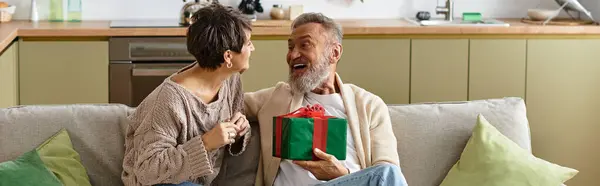A couple exchanges joyful smiles as they celebrate a special occasion in their cozy home. — Stock Photo