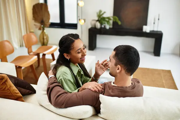 A beautiful couple shares a warm moment in their stylish living room, surrounded by holiday cheer. — Stock Photo