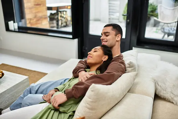 Couple se détend ensemble dans un appartement joliment décoré, célébrant l'esprit de Noël. — Photo de stock