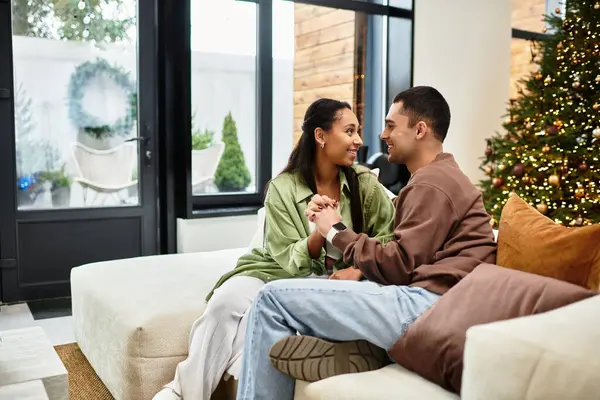A lovely couple shares a joyful time in their modern home, surrounded by festive decor. — Stock Photo