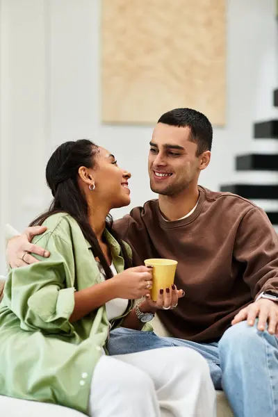 Beautiful couple shares holiday warmth in their stylish apartment, surrounded by festive decor. — Stock Photo