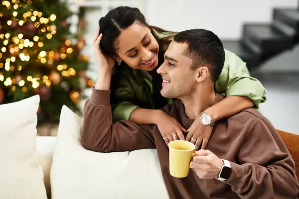 A beautiful couple shares love and laughter in their decorated modern apartment during the holidays. — Stock Photo